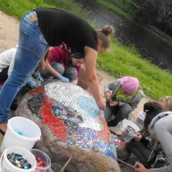 Mākslas skolas bērni apglezno parka akmeņus